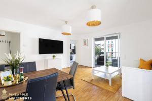 a dining room and living room with a table and a tv at PINEAPPLE APARTMENTS - Zwinger I - 80qm - 1x free parking in Dresden