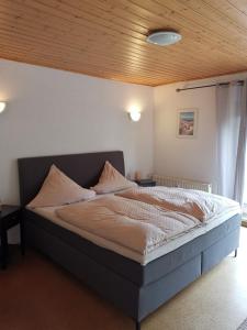 sypialnia z dużym łóżkiem i drewnianym sufitem w obiekcie Ferienwohnung Morbach w mieście Morbach