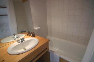 ein Badezimmer mit 2 Waschbecken und einer Badewanne in der Unterkunft Joker Appartements VTI in Val Thorens