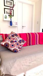 Una cama con una manta roja y rosa. en Moderno departamento en Palermo en Buenos Aires