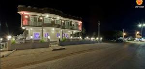 a large building with lights on a street at night at Geyi̇kli̇ Sunshi̇ne Hotel in Dalyanköy