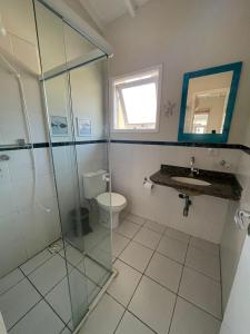 a bathroom with a glass shower and a toilet at Casa em condominio na Praia de Juquehy in São Sebastião