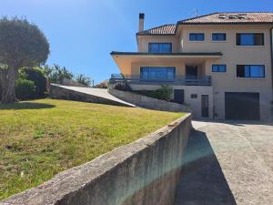 una casa con una pared de retención frente a un patio en Playa de la Sirenita, Canido, Vigo, en Vigo