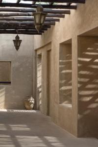 a hallway of a building with a vase on the floor at Bab Al Shams, A Rare Finds Desert Resort, Dubai in Dubai