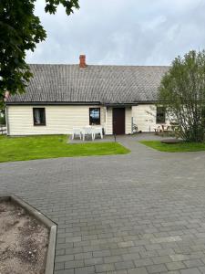 a white building with a picnic table in front of it at Engure apartment "Big one" in Engure