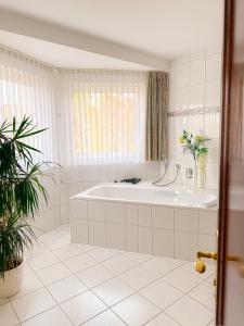 a white bathroom with a tub and a window at Hotel Stockhausen GbR in Schmallenberg