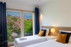 una camera da letto con due letti e una grande finestra di Les Hameaux De Buttaciolo a Cuo Altre 188 foto