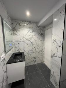 bagno con pareti in marmo bianco e bancone di Maestranzamarycentro a La Coruña
