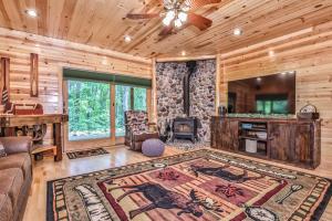 a living room with a couch and a television in a log cabin at Woodland Wonderland in Winchester