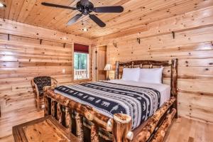 a log cabin bedroom with a bed and a ceiling fan at Woodland Wonderland in Winchester