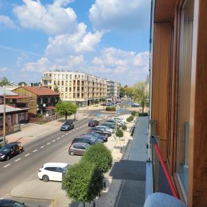 - un balcon donnant sur une rue avec des voitures dans l'établissement Queen Apartament Centrum z garażem, à Mińsk Mazowiecki