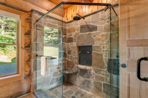 y baño con ducha y pared de piedra. en Spruce Moose Lodge, en Hartland