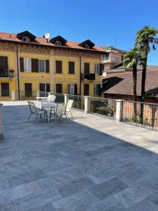 un patio con mesa y sillas frente a un edificio en Appartamento Montegrappa in centro a Varese, en Varese