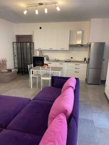sala de estar con sofá púrpura y cocina en Appartamento Montegrappa in centro a Varese, en Varese