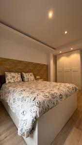 una camera da letto con un letto e un piumone bianco di Maestranzamarycentro a La Coruña