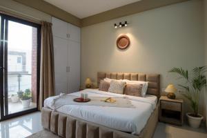 1 dormitorio con cama grande y ventana grande en BedChambers Serviced Apartment, Medicity, en Gurgaon