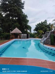 a large blue swimming pool with a gazebo at WCW Auberge in Saavedra