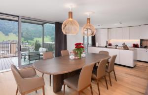 eine Küche und ein Esszimmer mit einem Tisch und Stühlen in der Unterkunft Swiss Hotel Apartments - Engelberg in Engelberg