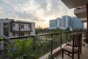 balcón con silla y vistas a la ciudad en BedChambers Serviced Apartment, Medicity, en Gurgaon