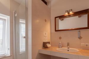 a bathroom with a sink and a mirror at Zum Spitzbuam in Attenkirchen