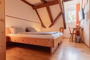 a bedroom with a wooden bed in a room with wooden beams at Zum Spitzbuam in Attenkirchen