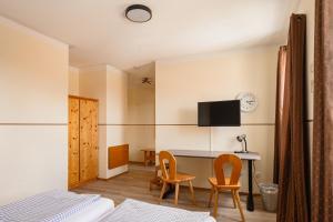 a bedroom with a desk and two chairs and a table at Zum Spitzbuam in Attenkirchen