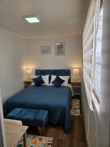 1 dormitorio con cama azul y almohadas azules en Guest House Club Hípico en Santiago