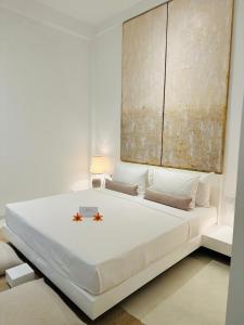 ヒッカドゥワにあるSaffron Robes Livingの白いベッドルーム(大きな白いベッド1台付)
