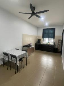 a living room with a table and a ceiling fan at Alsia Homestay in Kampong Beris Meraga +11 photos