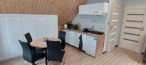 a small kitchen with a table and chairs in a room at Gościniec Polna Pszczoła in Zabór