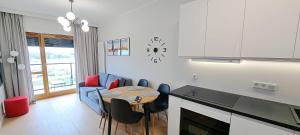a kitchen and living room with a table and chairs at Apartment No 235 in Gdańsk