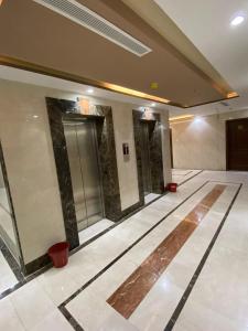 un vestíbulo vacío con ascensor en un edificio en فندق الزائر, en La Meca