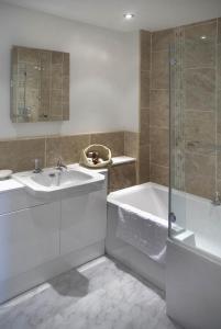 a bathroom with a tub and a sink and a shower at Lake Cottage , Middleton Hall Estate in Smeafield