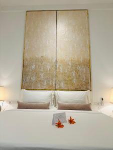 a white bed with a window and two stars on it at Saffron Robes Living in Hikkaduwa