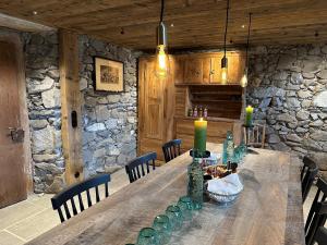 een houten tafel in een kamer met een stenen muur bij Alpen Hotel Post in Au im Bregenzerwald