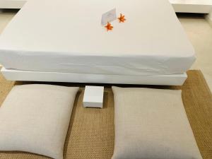 a white bed with two pillows on the floor at Saffron Robes Living in Hikkaduwa