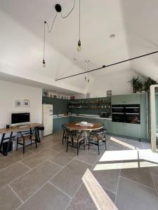 a kitchen with two tables and a kitchen with green cabinets at The Penthouse at Purfleet in King's Lynn