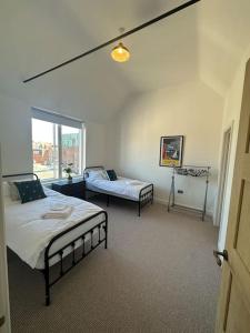 a bedroom with two beds and a window at The Penthouse at Purfleet in King's Lynn