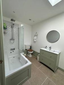 a bathroom with a tub and a sink and a toilet at The Penthouse at Purfleet in King's Lynn