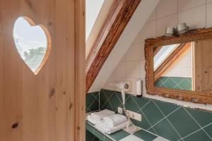a bathroom with a heart shaped mirror and towels at Zum Spitzbuam in Attenkirchen +72 photos