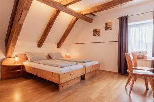 a bedroom with two beds and a table and chairs at Zum Spitzbuam in Attenkirchen