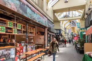 Una mujer caminando por una calle en un mercado en Modern and Spacious 2 bed in Brixton, en Londres