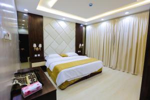 - une chambre avec un grand lit et une table dans l'établissement شقق مساكن الاطلال الفندقيه, à Riyad