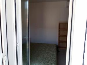 a bedroom with a bed and a glass door at Casa vacanze sul mare in SantʼAlessio Siculo
