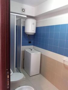 ein Badezimmer mit einem WC und einer blau gefliesten Wand in der Unterkunft Casa vacanze sul mare in SantʼAlessio Siculo
