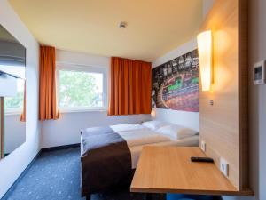 a hotel room with a bed and a table at B&B Hotel Augsburg-Süd in Augsburg