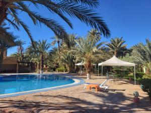 un complejo con piscina y palmeras en hotel jnane la kasbah 