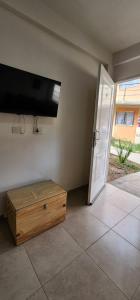 Pokój z drzwiami, telewizorem i stołem w obiekcie AIRES DEL CERRO 6 CON COCHERA w mieście Salta