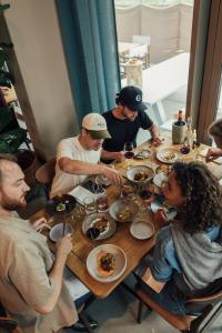 アムステルダムにあるHotel Jansen Amsterdam Bajeskwartierのテーブルの周りに座って食事をとる人々のグループ