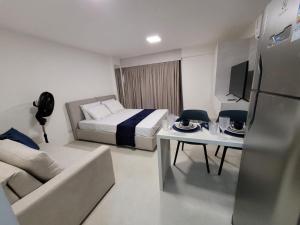 塔曼達雷的住宿－Studio Praia dos Carneiros Tamandare，酒店客房配有床、沙发和桌子。